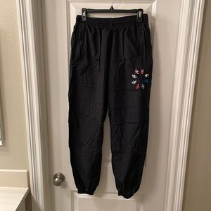 Adidas track pants with zippered pockets and unique logo detail